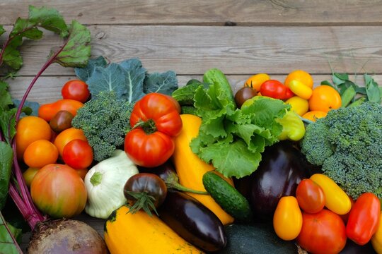 Many different colorful vegetables on a wooden background . Harvest and summer season concept. copy space