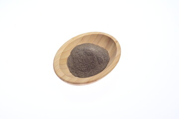 Ground pepper on a wooden bowl against a white background. Food. Spices.
