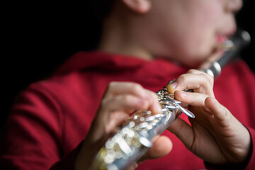 Selective focus of boy playing flute