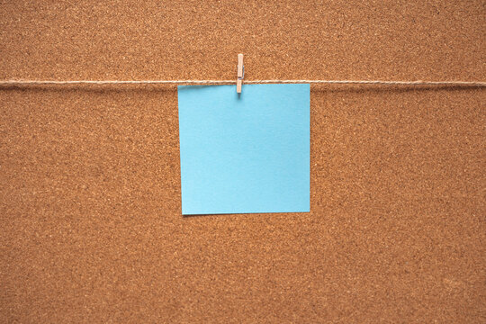 Colorful sticky notes on cork bulletin board. Blue reminder sticky note on cork board, empty space for text. Blank sticky note pinned on a cork bulletin board. Blank note on cork message board