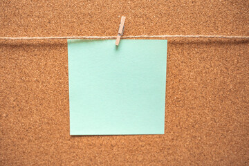 Colorful sticky notes on cork bulletin board. Blue reminder sticky note on cork board, empty space...