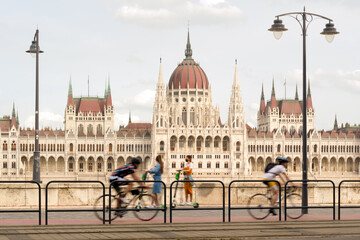 Obraz premium Blurred bicyclists on a Bike Lane against Hungarian parliament building