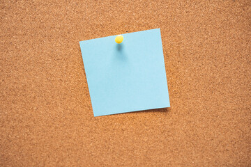 Colorful sticky notes on cork bulletin board. Blue reminder sticky note on cork board, empty space for text. Blank sticky note pinned on a cork bulletin board. Blank note on cork message board