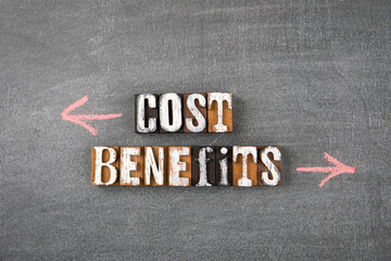 Cost and Benefits. Words from wooden letters on a dark board