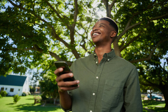 Mixed race male farmer standing outdoors holding cellular device