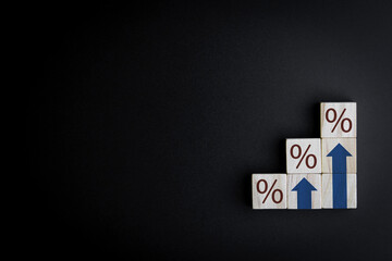 Stepped wooden blocks with percentage signs and up arrow symbols. concept of Finance and Mortgage Interest Rate