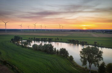 Amazing sunset over the field with wind turbines in Poland