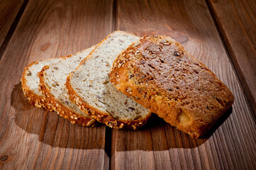 Bread made from natural products, on live sourdough, without baker's yeast, cut into skibbles on a wooden table surface.