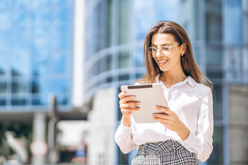 Business woman using tablet near modern business center.