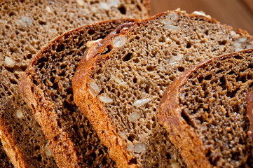 Bread made from natural products, on live sourdough, without baker's yeast, cut into skibbles on a wooden table surface.