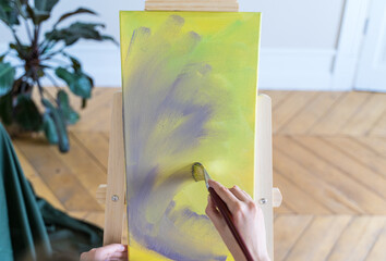 The artist paints a picture. Close-up. Contemporary art in the gallery. Creation artwork