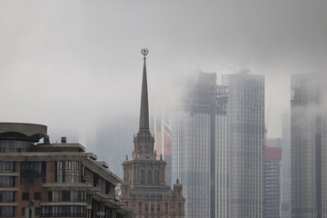 Rain and fog in Moscow. View to Stalin high rise building and skyscrapers of Moscow international business centre in clouds