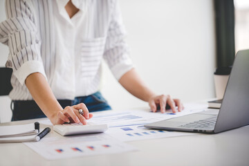 businessman or accountant who are using a calculator to calculate business data Accounting documents and laptop computer at the office business idea