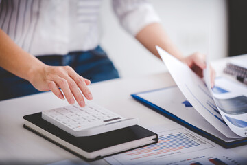 businessman or accountant who are using a calculator to calculate business data Accounting documents and laptop computer at the office business idea