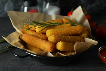 Concept of tasty food with cheese sticks on dark wooden table