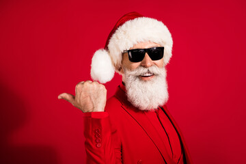 Photo of cool pretty age gentleman wear new year costume headwear pointing thumb back empty space isolated red color background