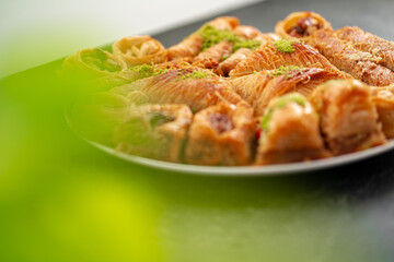 Delicious baklava dessert in oriental setting on black background