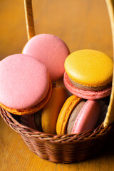 Sweet and bright strawberry and orange macarons in a gift basket. French dessert.