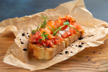 bruschetta with salmon and tomatoes. Against a dark background.