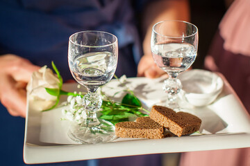 Parents in the trechy meet newlyweds with salt and drinks