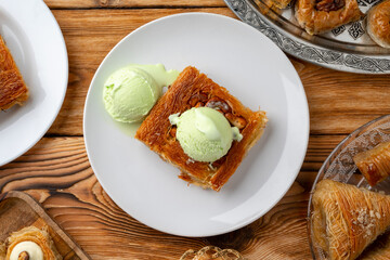Turkish dessert kunefe served with ice cream on wooden background
