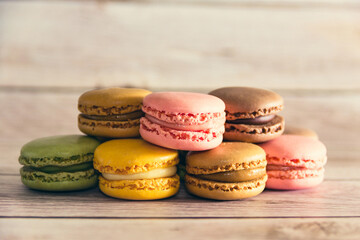 Dessert of French macarons in pastel colors on wood. Copy space. Selective focus.
