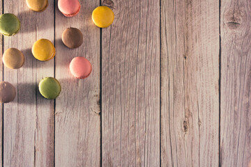 Dessert of French macarons in pastel colors on wood. Copy space. Selective focus.