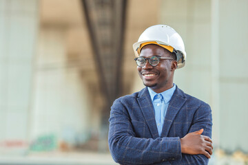 Portrait of african american man architect at building site with folded arms looking at camera....