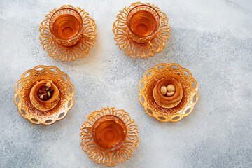 Turkish baklava and Turkish tea in oriental dishes on gray background