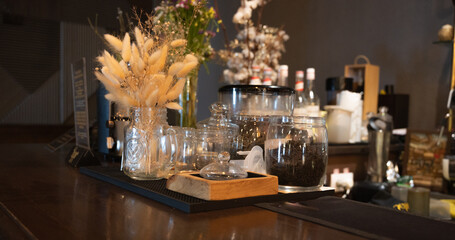 Tea in glass jars. Bar counter in a cafe. The interior of the bar is in dark shades