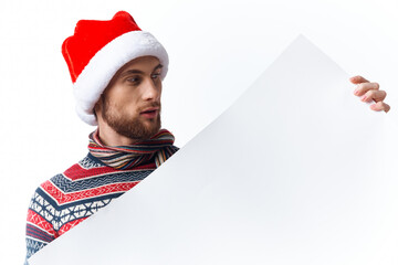 Cheerful man in a christmas hat with white mockup poster christmas isolated background