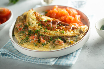 Traditional homemade omelette with tomatoes and salmon