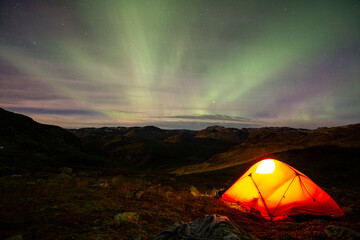 tent in the mountains under the northern lights