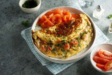 Traditional homemade omelette with tomatoes and salmon