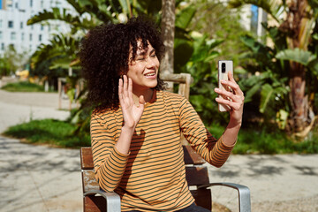 Smiling young woman waving during a video call