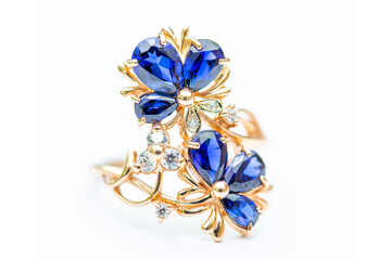 Gold ring with blue sapphires on a white background