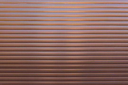 Brown roller shutter door or curtain. Grunge brown metal foldable door background and texture.