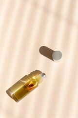 Top view of roller bottle on striped shadow beige background.