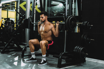 Fototapeta na wymiar Strongman squatting with weights in a gym