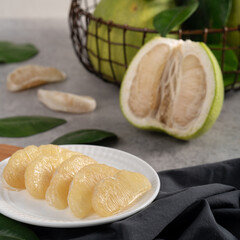 Fresh pomelo fruit on gray cement background.