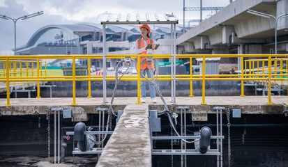 Worker under checking the waste water treatment pond industry large to control water support industry.	