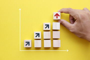 Wooden blocks lined up with up arrow icon The process of creating a successful business idea