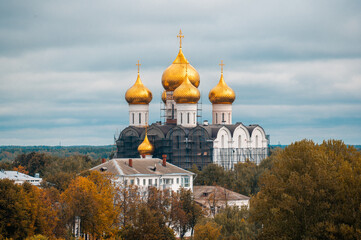 Fototapeta na wymiar autumn, Christian church with golden domes on the background of autumn foliage. Church Surrounded By Autumn Colors