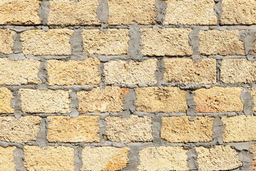 Stone bricks from limestone laid by a wall and  by cement. Background texture. Natural Rough Stone Wall Texture. Front view, closeup.