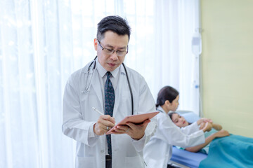 Portrait of senior Doctor in examination room medical office.