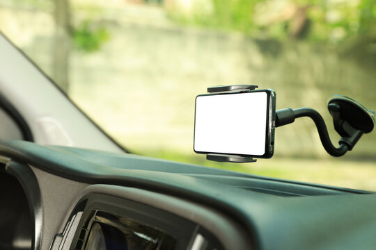 Car Holder With Modern Mobile Phone On Windshield Of Automobile. Mockup For Design