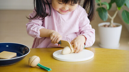 子育て・育児　野菜のおもちゃでおままごとをする3歳の子供