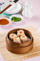 Assorted Chinese Dimsum in bamboo basket. Dimsum is a large range of small dishes that Cantonese people traditionally enjoy in restaurants for breakfast and lunch.