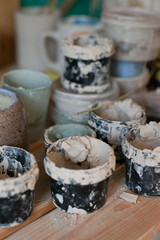 Jars with clay on the shelf at pottery studio