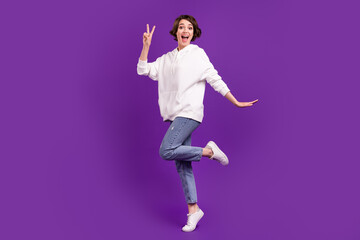 Obraz premium Full length body size photo girl smiling in casual clothes showing v-sign isolated vivid purple color background